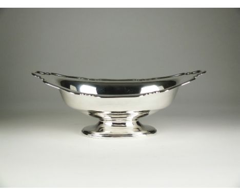A silver oval pedestal dish, Atkin Brothers, Sheffield 1917, with shaped scroll rim and raised on oval foot, 11cm high, 29.5c