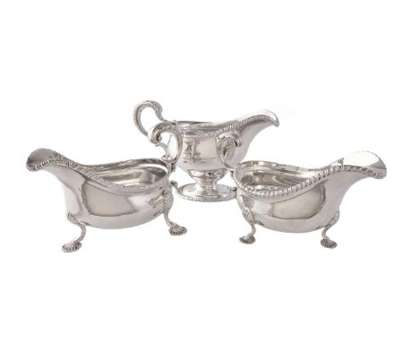 The silver oval sauce boats with gadrooned rims, one pedestal by William Hutton & Sons, Sheffield 1913, with a leaf-capped do