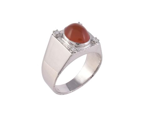 A diamond and cornelian dress ring, the oval cabochon cornelian in a textured square panel, with four claw set brilliant cut 