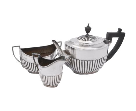 A Victorian silver three piece oval half gadrooned tea set by William Hutton & Sons, London 1893, the tea pot with a composit