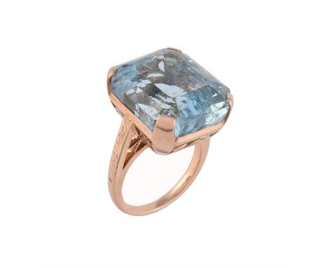 A 1930s aquamarine dress ring, the step cut aquamarine with canted corners, estimated to weigh 21 carats, to a pierced floral