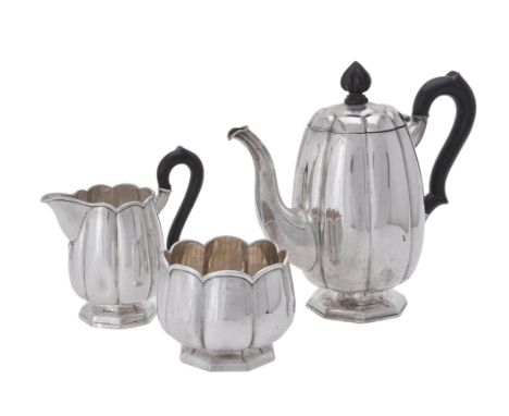 A German silver three piece lobed tea set by J. Demessieur, Berlin circa 1850, the tea pot with a cone finial and scroll hand