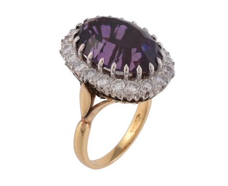 An 18 carat gold amethyst and diamond cluster ring, the oval mixed cut amethyst within a surround if brilliant cut diamonds, 