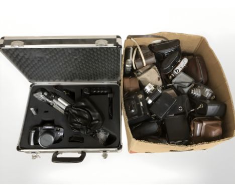 A collection of vintage cameras and an aluminium camera case containing a Tamashi camera with accessories. 