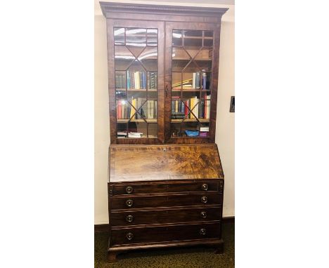 A George III mahogany glazed bookcase on bureau, circa 1780, in a Thomas Chippendale manner, dental cornice above a two panel