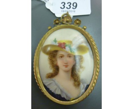 An early 20thC oval painted porcelain portrait plaque, a young woman wearing a fashionable hat  3.5'' x 2.5'' in a gilded twi