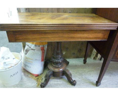 A mid 19thC rosewood card table, the rotating top enclosing a green baize lined interior, over a turned and carved pedestal t