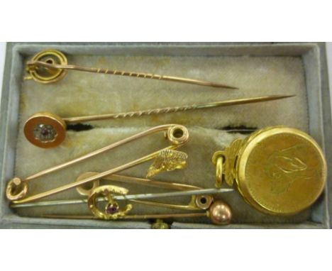 Six various yellow and gold coloured metal stick and other pins, one mounted with a fox head; and a pendant locket, engraved 