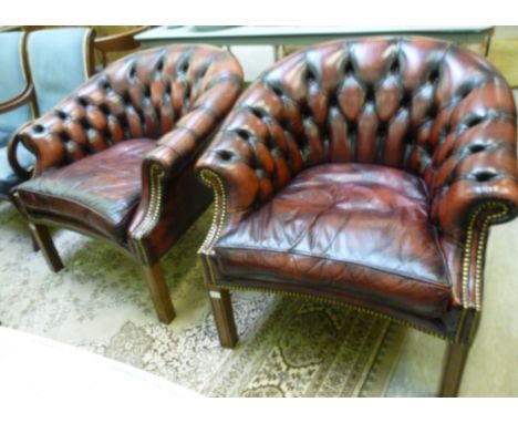 A pair of office reception tub style chairs, stud and part button upholstered in burnished brown hide with a cushion seat, ra