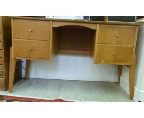 A 1960s light oak finished kneehole desk, raised on twin, two drawer pedestals and splayed feet  30''h  48''w        F