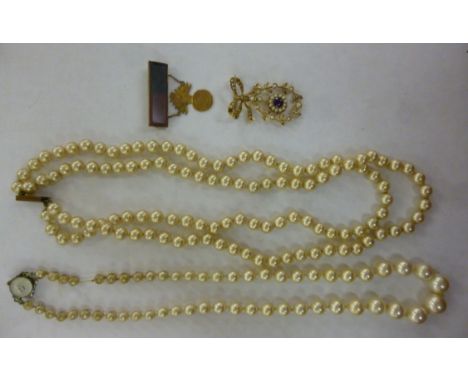 A 9ct gold ribbon tied and seed pearl set brooch, set with an amethyst pendant; a 9ct gold bar brooch, bearing a folded medal