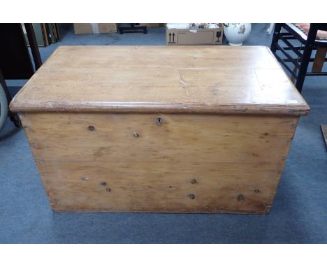 A VICTORIAN STRIPPED PINE TRUNK with iron carrying handles 83 x 47 x 45cm high