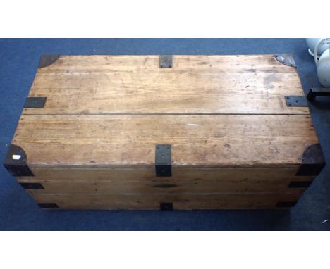A 19th CENTURY STRIPPED PINE TRAVELLING TRUNK with metal reinforcements and handles 101cm wide