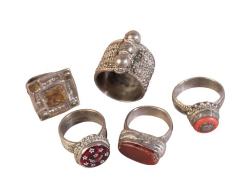 AN OMANI WHITE METAL WEDDING RING the face with triple ball motif, together with four similar semi-precious gem and hardstone