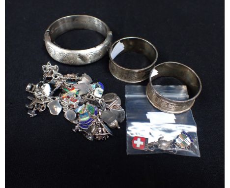 A SILVER CHARM BRACELET, A SILVER BANGLE and two silver napkin rings
