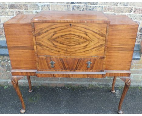 A 1930s WALNUT BUREAU/DRINKS CABINET by Nissons Furniture, London, with raised centre section, and cupboards to the ends, on 