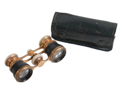 A PAIR OF BINOCULAR OPERA GLASSES in brass with mother of pearl eye cups and focus wheel, barrels bound in blue leather, no s