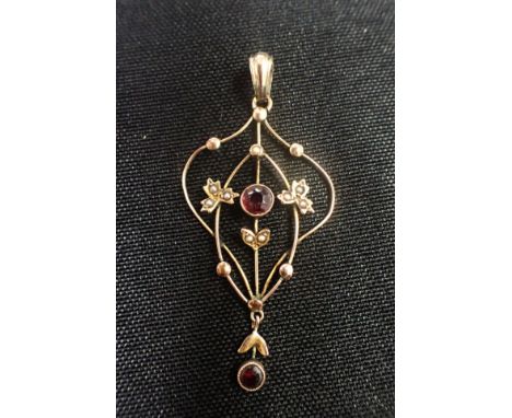 AN EDWARDIAN 9CT GOLD, GARNET AND SEED PEARL PENDANT of Art Nouveau design