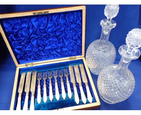 A PAIR OF VICTORIAN CUT-GLASS DECANTERS and a cased fruit cutlery set with mother-of-pearl handles