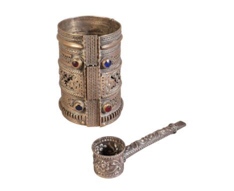 AN OMANI WHITE METAL BRACELET the pierced and embossed decoration with two red and two blue glass faceted beads and a white m