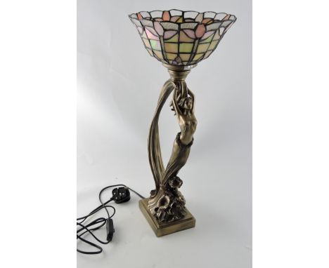 An Art Nouveau style gilt figural table lamp, with leaded stained glass shade, H. 54cm.