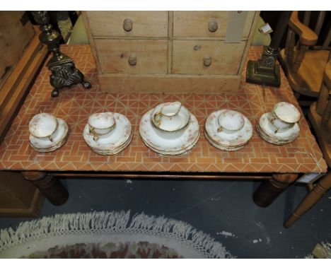 A mid-19th century tea service for eight place settings, decorated with floral sprigs, gilded lips and handles, slop bowl and
