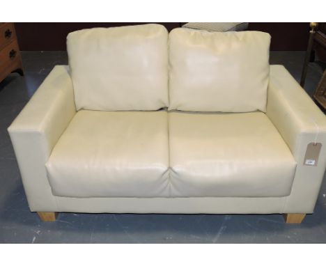 A contemporary cream pleather two seater sofa.