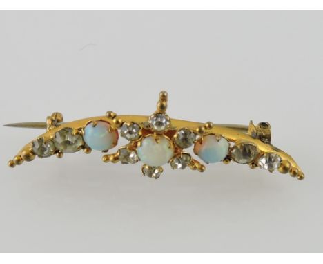 An early 20th century opal and white sapphire crescent shaped brooch, set in yellow metal, 2.7g.