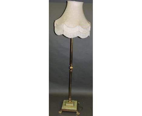 A brass and onyx standard lamp, the reeded support incourporating a central foliate knop, on a stepped base with paw pad feet
