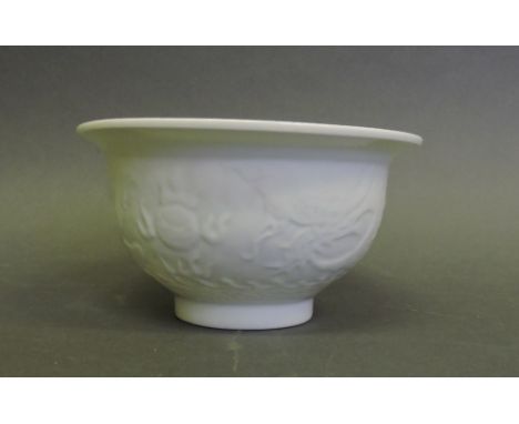 A Chinese white porcelain bowl, the circular body mouled with dragon, pheonix and flaming pearl, Dia 14cms.