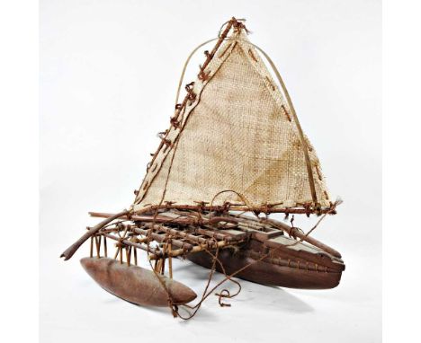 A carved wooden model of a Samoa canoe with outrigger and woven sail, 84cm long