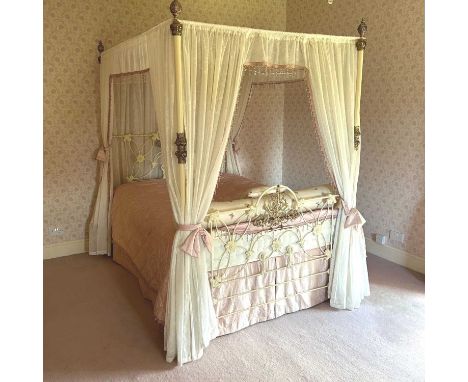 An early 20th century French cream painted iron and brass four poster bedstead, with turned finials and drapes150w x 210d x 2