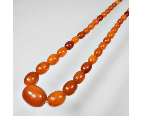 An amber coloured necklace, with a single row of graduated beads, 51g, 61cm longOverall condition is complete and wearable. S