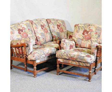 An Ercol elm sofa, with floral cushions, together with matching armchair (2)214w x 85h x91d cm