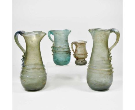 An iridescent green glass jug, probably late Imperial Roman, of tapered form with applied decoration, 21cm high, together wit
