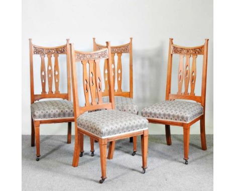 A set of four Arts and Crafts light oak high back dining chairs, with upholstered seats (4)