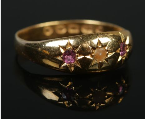 A Victorian 22ct gold three stone ring set with two pink rubies and a seed pearl. Assay marks for Sheffield 1893. Size P. 3.1