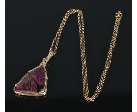 A Eudialyte pendant wrapped in yellow metal wire mount on 9ct chain.  