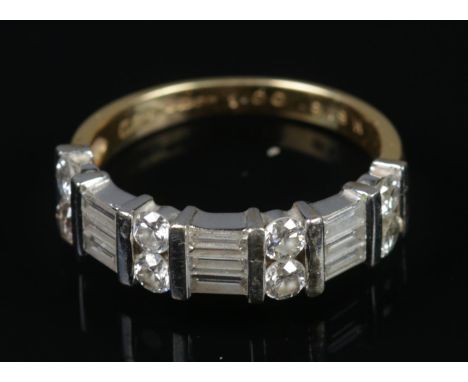 An 18ct gold and diamond ring with 17 stones alternating between brilliant and baguette cut. Stamped 18ct to inside of band a
