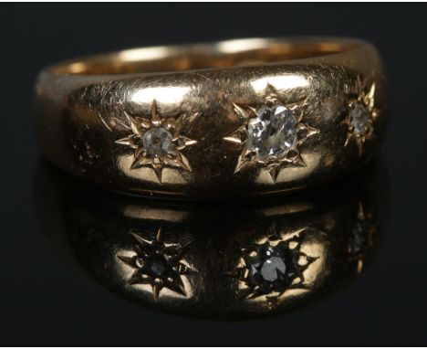 An 18ct Gold and three stone 'gypsy set' diamond ring. Size N. Total weight: 5.0g.  