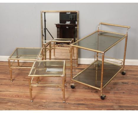 A yellow metal and glass Art Deco style furniture set including two tier hostess trolley, pair of side tables and bevel-edge 