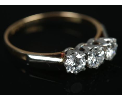 An 18ct gold three stone diamond ring. Size N. 2.21g.  