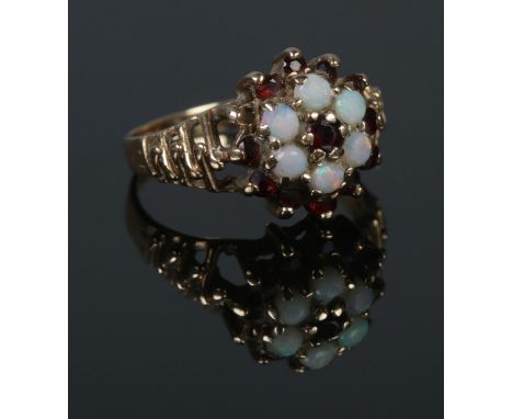 A 9ct Gold Opal and Garnet cluster ring, with waved shoulders. Size MÂ½. Total weight: 3.1g  