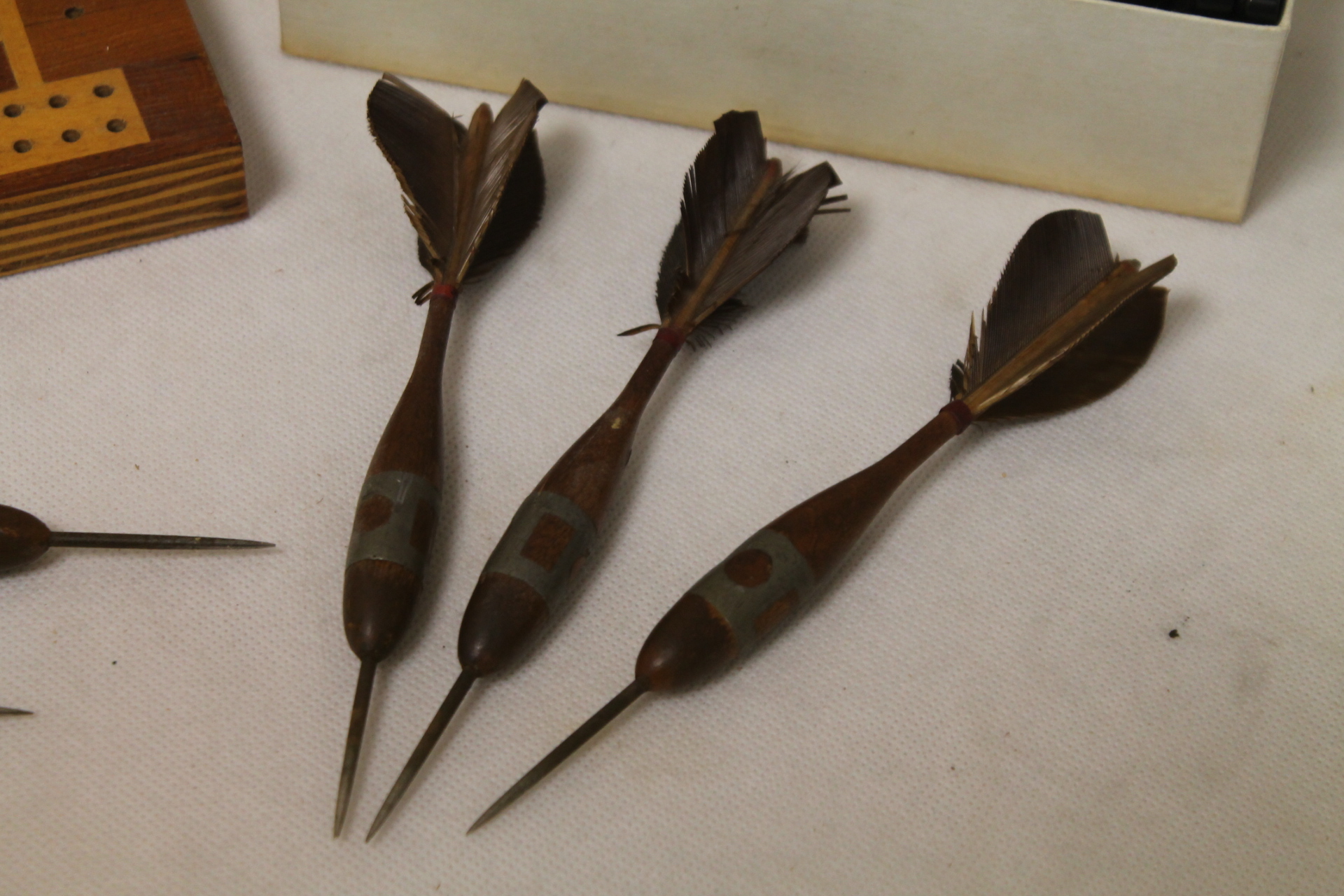 Set of six antique wooden darts with feather flights, two cribbage
