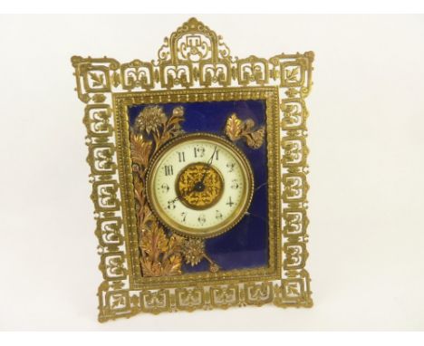 Late Victorian easel clock of aesthetic style with blue glass mask and coloured brass spray and pierced frame.  27cm. 