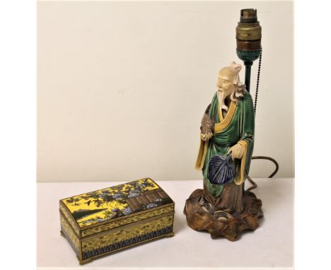 Early 20th cent. Oriental table lamp, the wooden base surmounted with a pottery figure of a deity holding a fish and fan, 36c