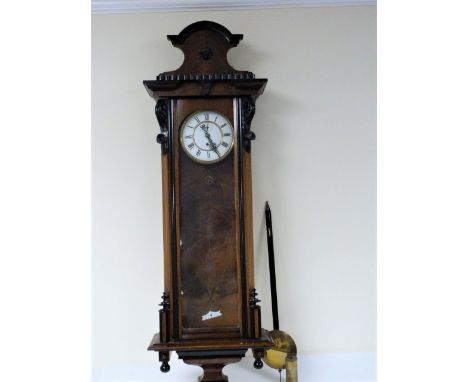 Vienna wall clock, weight driven, with two piece enamel dial in embossed walnut case of typical style.  26cm.