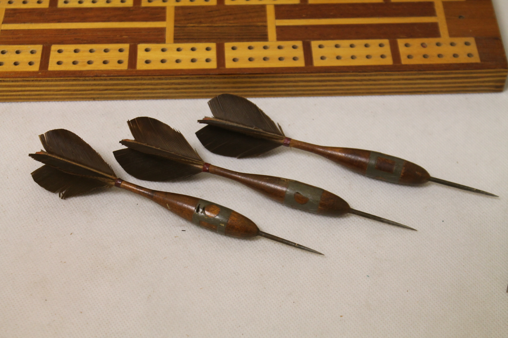 Set of six antique wooden darts with feather flights, two cribbage