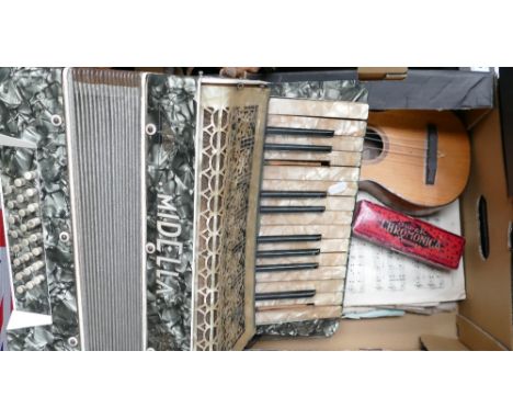 A mixed collection of items including musical interests such as an accordion, ukulele, sheet music etc. 