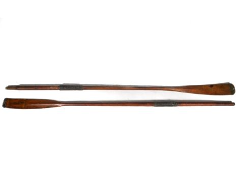 A pair of vintage wooden rowing oars. With banded metal to the ends and rubber handles, L229cm.